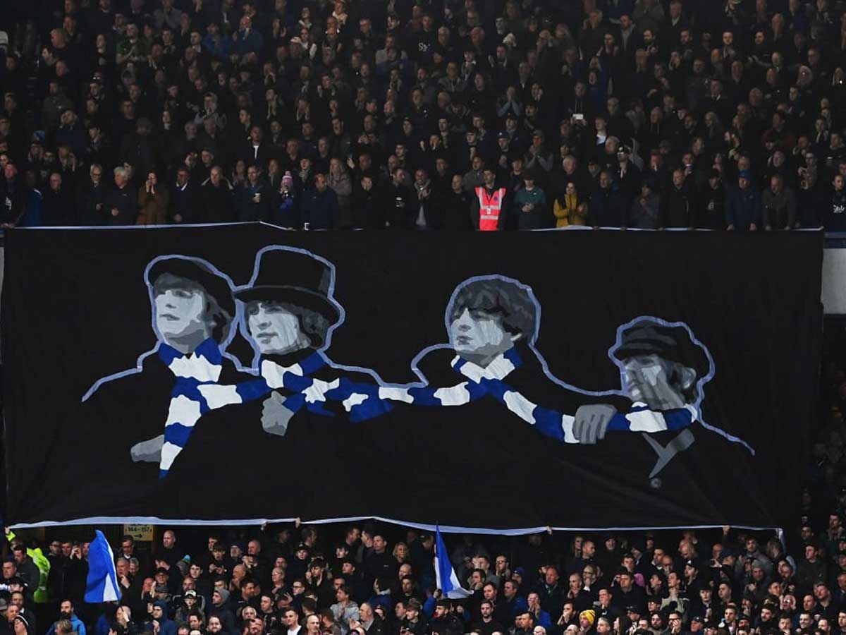 LIVERPOOL, ENGLAND - APRIL 03: Fans show their support from the stands, displaying a banner of The Beatles wearing an Everton scarf