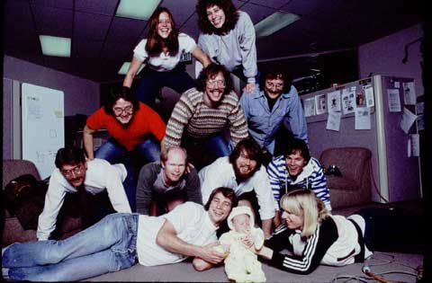 Here's the software team, photographed for Rolling Stone in January 1984, demonstrating teamwork in a human pyramid. On top: Rony Sebok, Susan Kare. Middle row: Andy Hertzfeld, Bill Atkinson, Owen Densmore. Bottom row: Jerome Coonen, Bruce Horn, Steve Capps, Larry Kenyon. In front: Donn Denman, Tracy Kenyon, Patti Kenyon